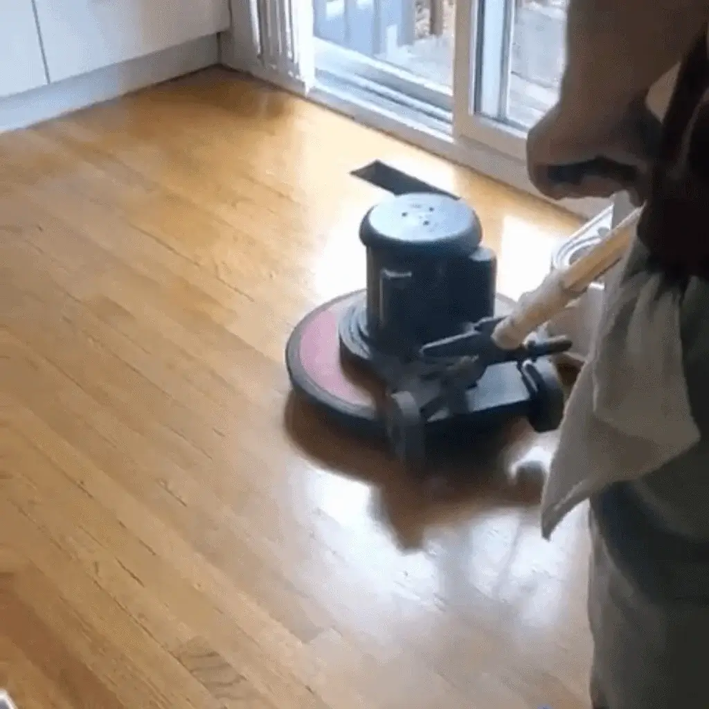 Carpet Cleaning Group technician using a rotary buffer to polish hardwood floors in a Chicago home, restoring their natural shine